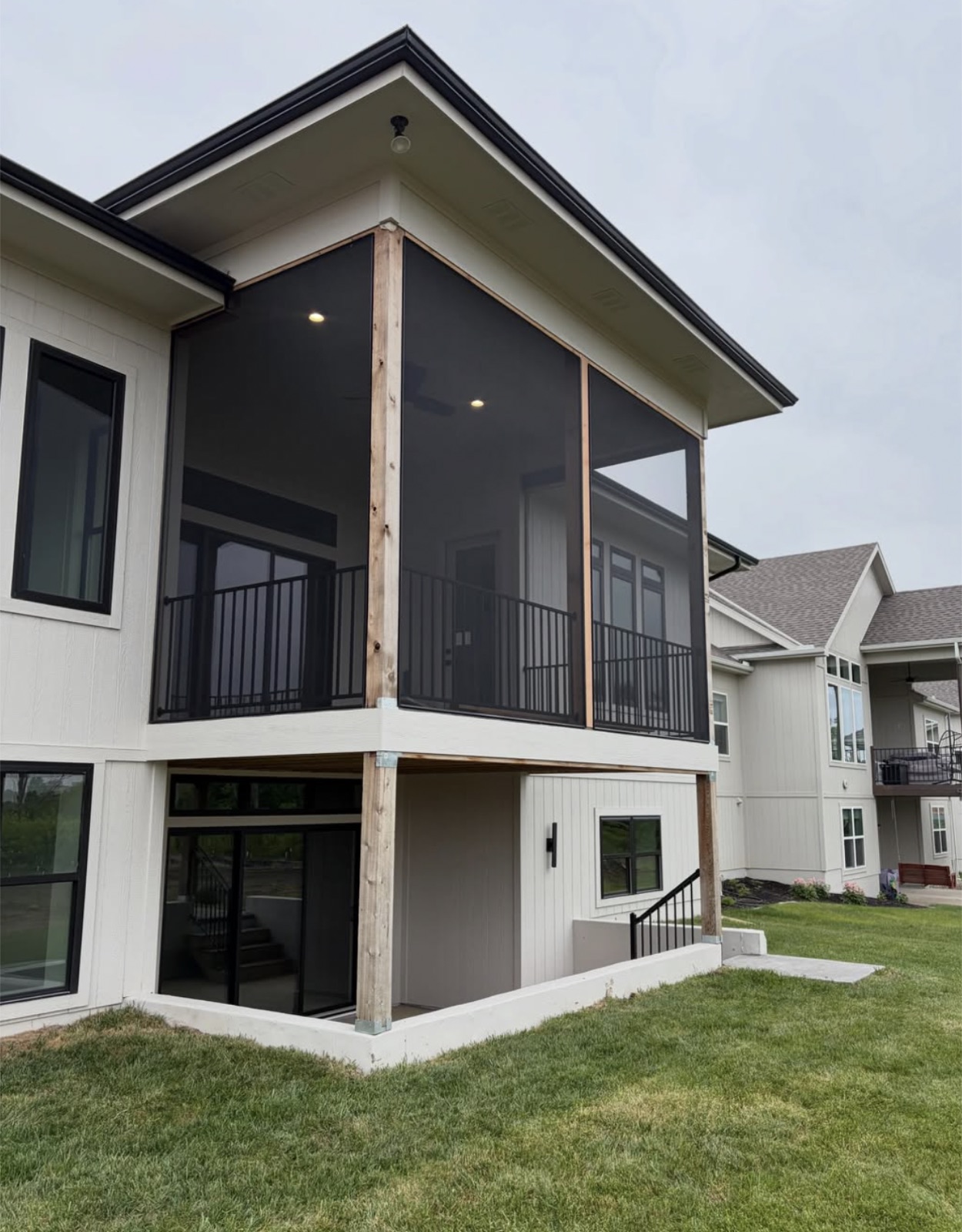 Elevated screened deck with black railing and large screen openings